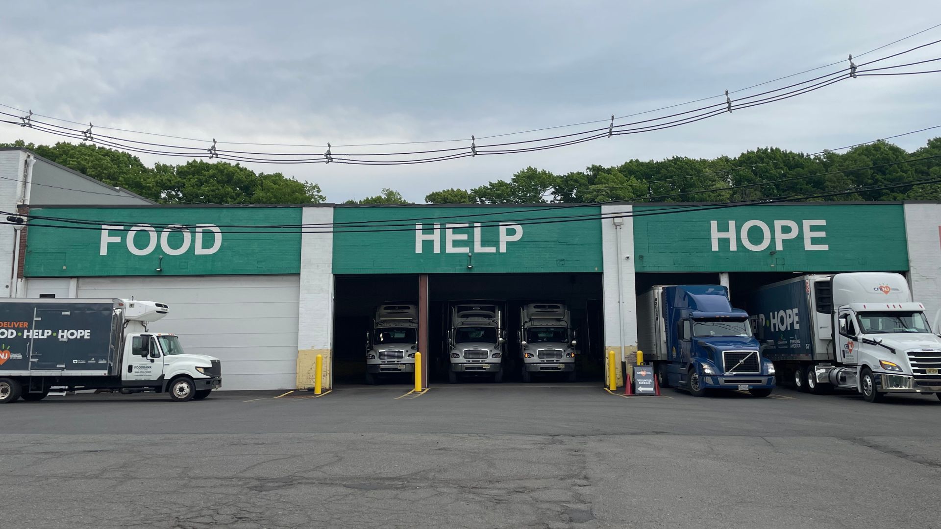 Un almacén con las palabras "Alimentos, ayuda, esperanza" sobre las entradas de los camiones comerciales que entregan alimentos.